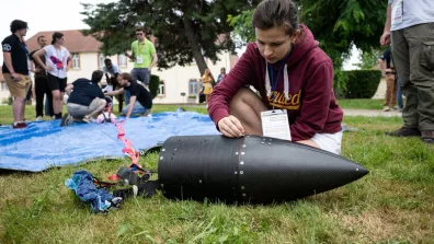 Une jeune étudiante en train d'assembler une fusée sur la pelouse