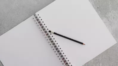 Un carnet vierge avec un crayon sur une surface en béton