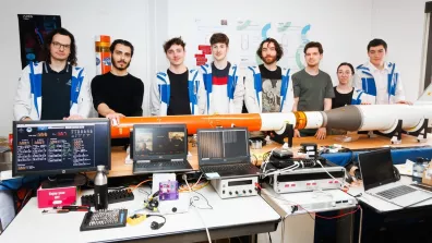 Des étudiants posant avec une maquette de mini-fusée