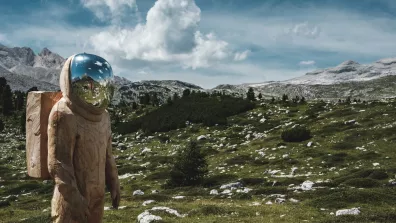 Un astronaute en bois debout sur une montagne avec une autre montagne en arrière-plan