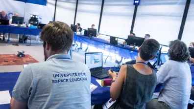 Un groupe de personnes assises à des tables lors d'une conférence