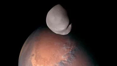 Mars et, au premier plan, la face cachée de sa lune Déimos capturées par la sonde Mars Hope.