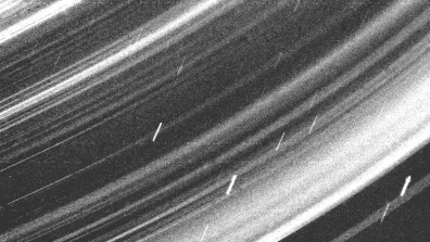 Photo prise par la sonde Voyager 2 des anneaux d’Uranus. Les petits traits verticaux que l’on peut voir sont des particules de poussière. 