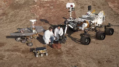 3 générations de rovers martiens : Sojourner devant, Spirit à gauche et Curiosity à droite. Les progrès (tant technologiques que sur la maitrise de l’atterrissage) permettent d’envoyer des rovers toujours plus massifs et sophistiqués.