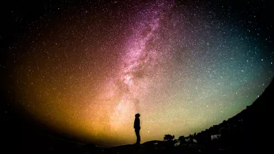 Une personne seule, de nuit, regarde le ciel étoilé