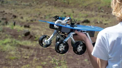 Un enfant tient un rover martien miniature