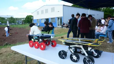 Restitution des travaux Proximars 2026 sur le terrain martien du CNES, avec des rovers au premier plan.