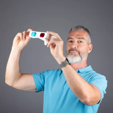 Laurent Lebegue tenant dans les mains une paire de lunettes anaglyphes.