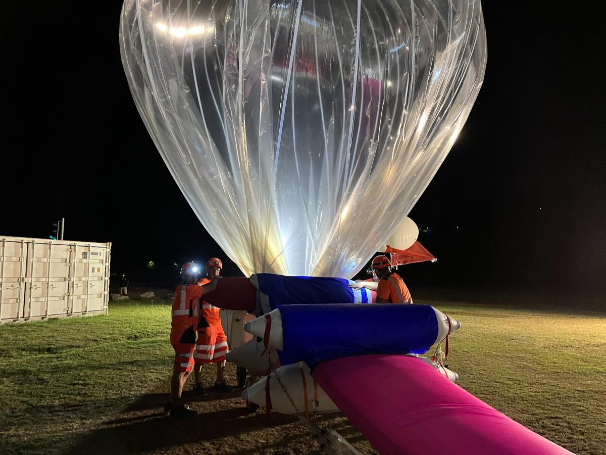Déploiement et remplissage de l’enveloppe en hélium d'un ballon avant son lâcher.