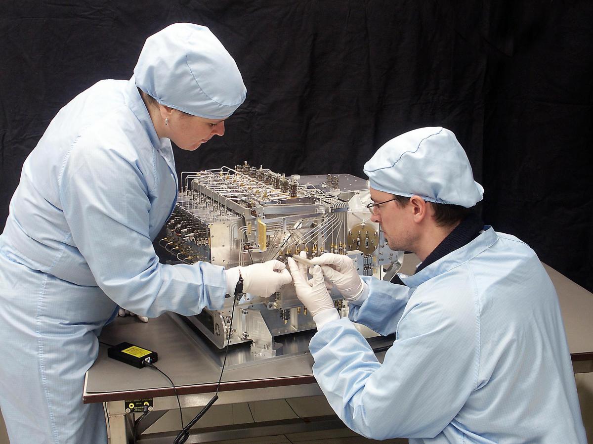 Deux techniciens travaillant sur une partie de HIFI Deux techniciens travaillant sur une partie de HIFI