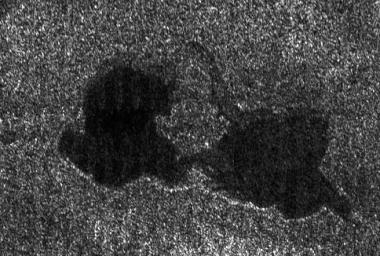 This Cassini radar image shows two lakes &quot;kissing&quot; each other on the surface of Saturn&#039;s moon Titan. Copyright : NASA/JPL.